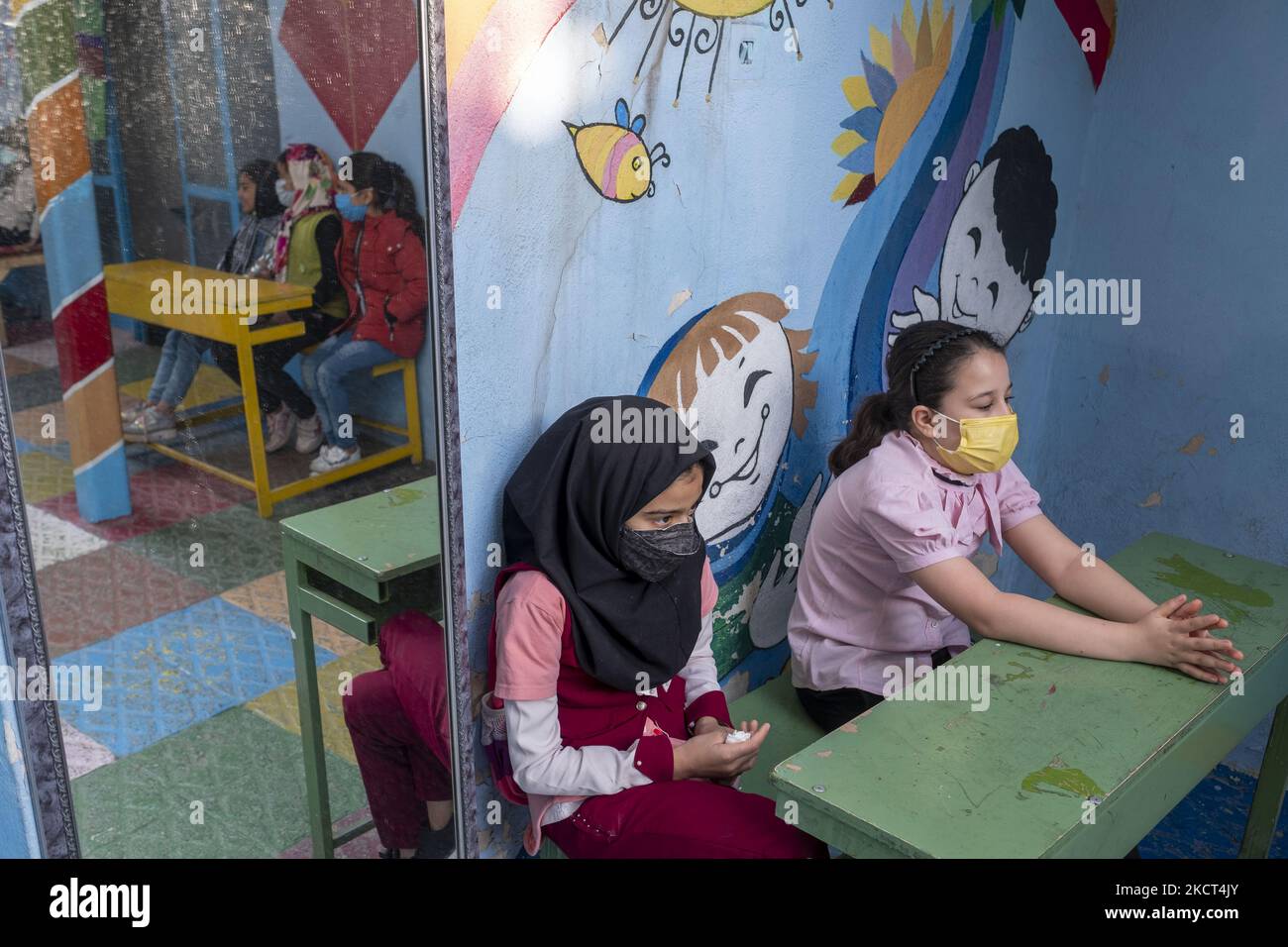 Le studentesse afghane rifugiate siedono sui banchi della scuola di Farhang nel primo giorno del nuovo anno accademico? Nel sud di Teheran il 1 novembre 2021. La scuola di Farhang è stata fondata nel 2000 dal rifugiato afgano Nader Mousavi che si è laureato in sociologia presso l'Università di Teheran, per i bambini rifugiati afghani, E ora due anni dopo l’inizio dell’epidemia COVID-19 in Iran, dove la scuola operava a tempo parziale, ha iniziato a funzionare a tempo pieno e le scolaresche e gli scolari afghani possono frequentare la scuola. Le famiglie non devono pagare i soldi per la lezione perché è gratuita Foto Stock