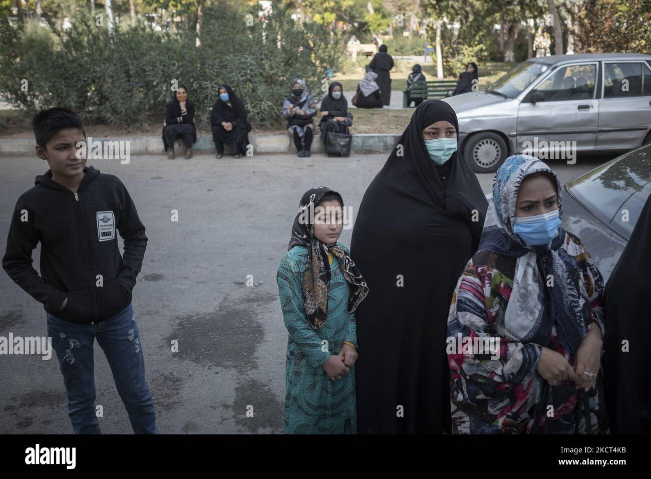 Famiglie di studentesse afghane rifugiate e scolari aspettano i loro figli mentre si levano in piedi fuori dalla scuola di Farhang nel primo giorno del nuovo anno accademico? Nel sud di Teheran il 1 novembre 2021. La scuola di Farhang è stata fondata nel 2000 dal rifugiato afgano Nader Mousavi che si è laureato in sociologia presso l'Università di Teheran, per i bambini rifugiati afghani, E ora due anni dopo l’inizio dell’epidemia COVID-19 in Iran, dove la scuola operava a tempo parziale, ha iniziato a funzionare a tempo pieno e le scolaresche e gli scolari afghani possono frequentare la scuola. Le famiglie fanno h Foto Stock