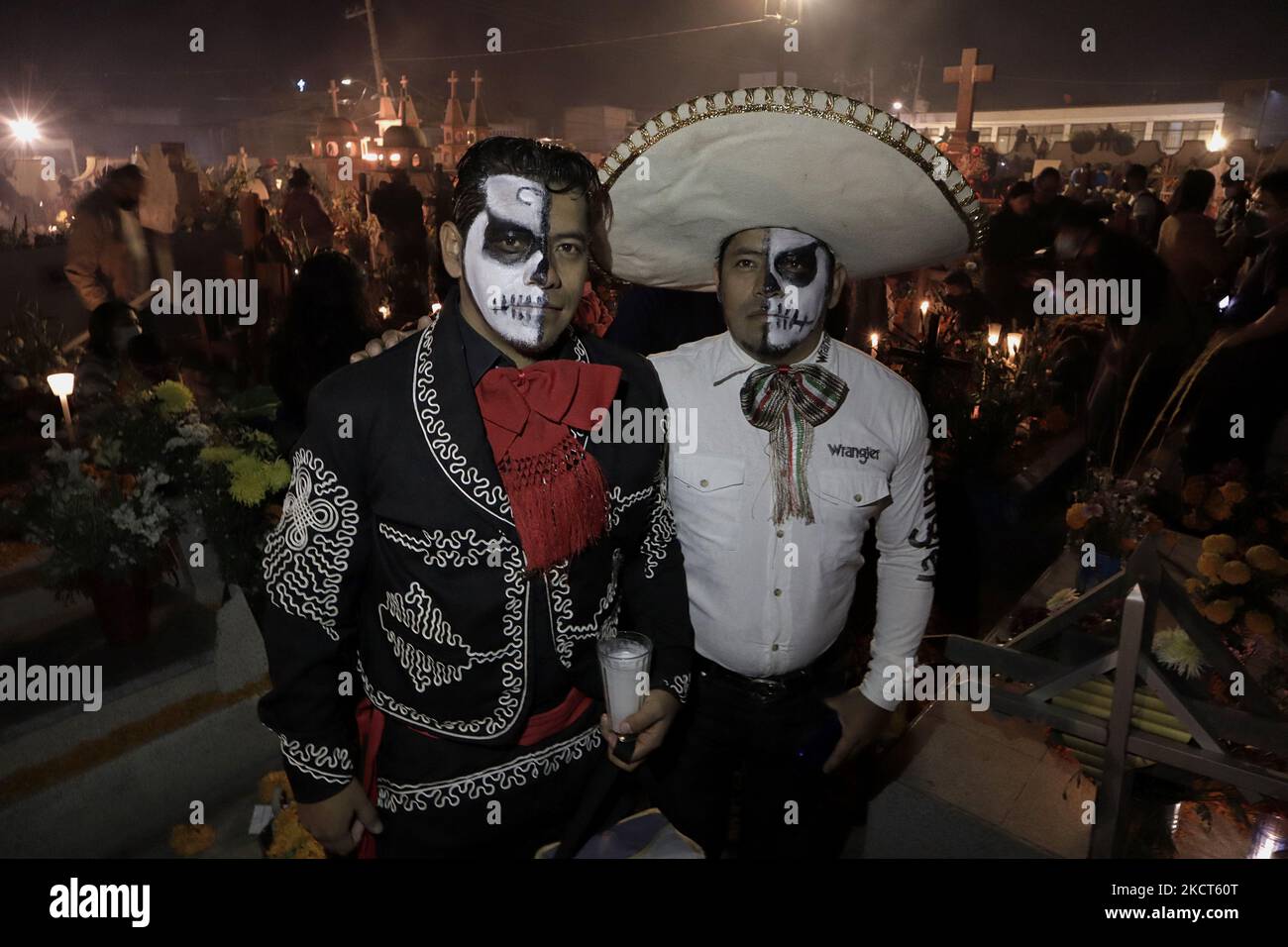 Due persone che indossano il cranio e le ossa incrociate si compongono e vestite come mariachi posa all'interno del cimitero di San Andrés Mixquic, Tláhuac, in occasione del giorno dei morti in Messico durante l'emergenza sanitaria COVID-19 e il semaforo verde epidemiologico nella capitale. (Foto di Gerardo Vieyra/NurPhoto) Foto Stock