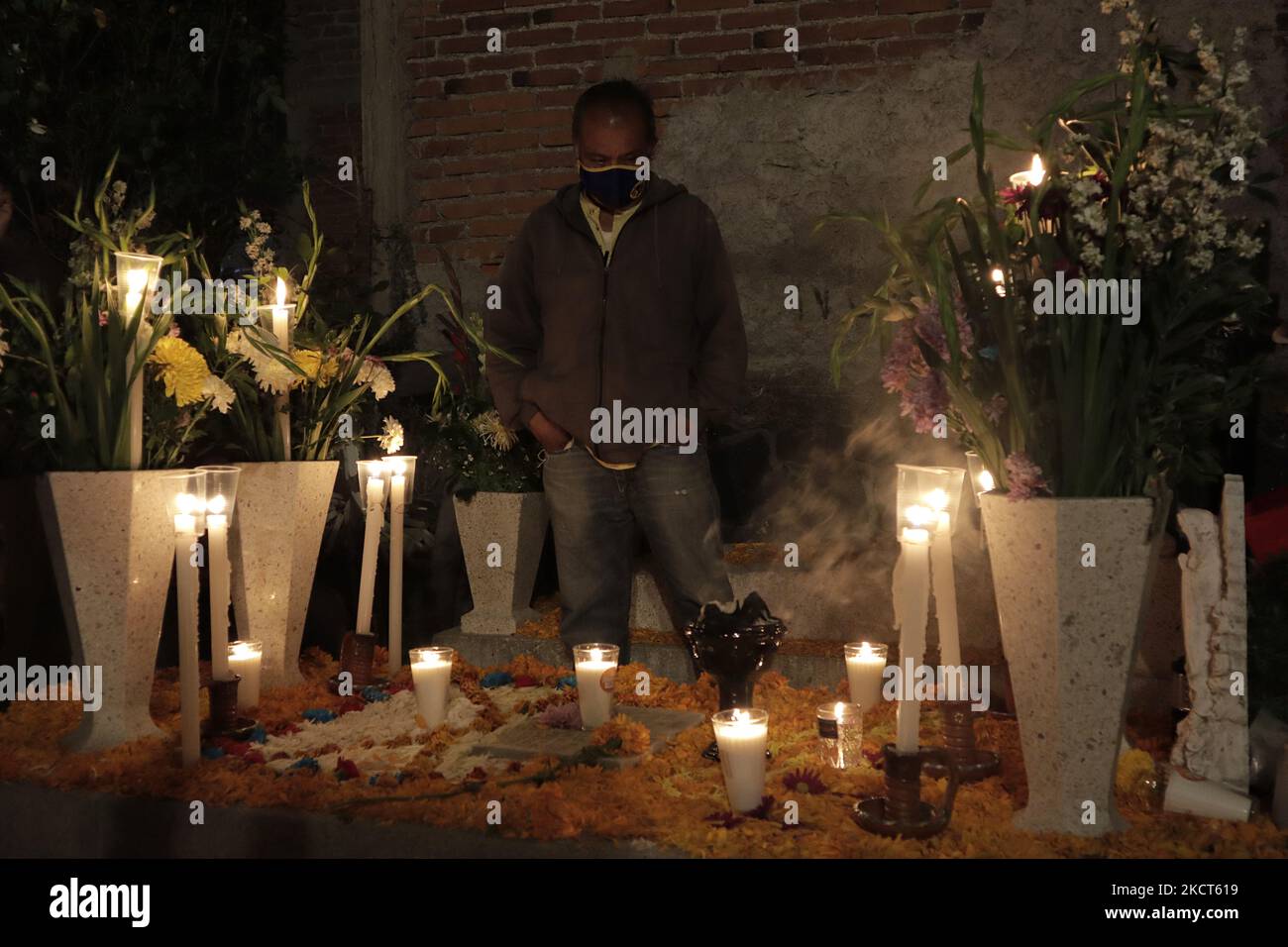 I parenti visitano le tombe dei loro cari all'interno del cimitero di San Andrés Mixquic, Tláhuac, per illuminarle in occasione della Giornata dei morti in Messico durante l'emergenza sanitaria COVID-19 e il semaforo verde epidemiologico nella capitale. (Foto di Gerardo Vieyra/NurPhoto) Foto Stock