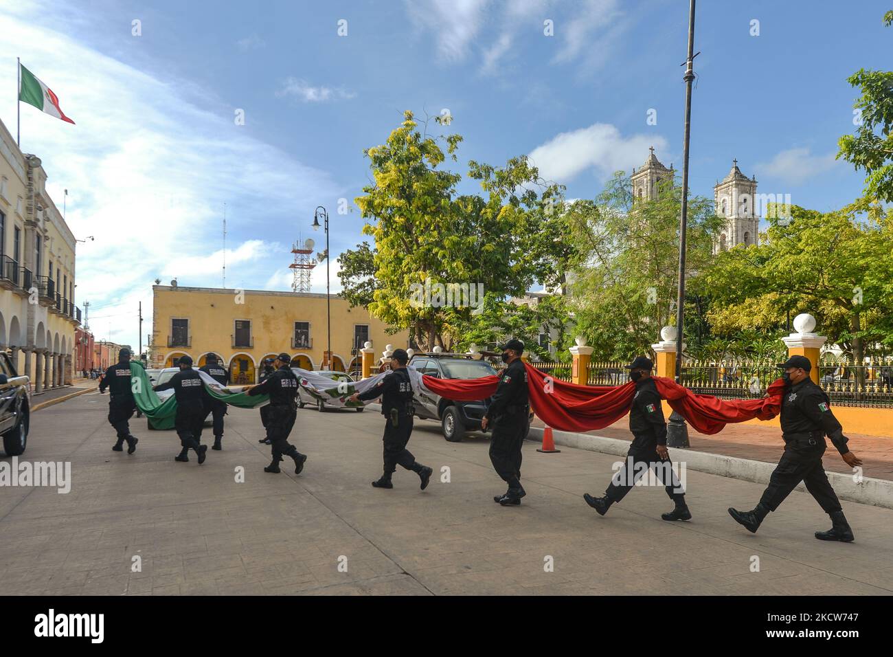 I membri della polizia municipale (Policía Municipal de Valladolid) portano la bandiera nazionale del Messico al Municipio dopo la breve cerimonia di El Día de la Revolucion (Giornata della Rivoluzione), una festa nazionale che commemora l'inizio della Rivoluzione messicana il 20 novembre 1910. Le celebrazioni ufficiali della Giornata della Rivoluzione sono state annullate a causa della pandemia del Covid-19. La città di Valladolid fu il luogo della 'prima scintilla della Rivoluzione messicana', conosciuta anche come il piano Dzelkoop, una rivolta iniziata il 4 giugno 1910, da Maximiliano R. Bonilla e da altri leader del CE elettorale indipendente Foto Stock