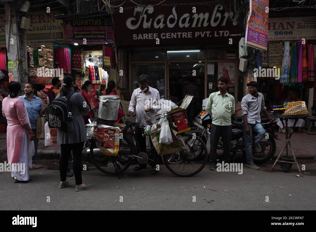 I fornitori di cibo di strada si trovano lungo una strada mentre attendono i clienti in un mercato a Nuova Delhi, India, il 24 novembre 2021. La Reserve Bank of India prevede una crescita del PIL del 9,5 per cento quest'anno fiscale, mentre la proiezione media varia tra il 8,5 per cento e il 10 per cento, rispetto alla precedente stima del 8 per cento per l'anno civile 2022. (Foto di Mayank Makhija/NurPhoto) Foto Stock
