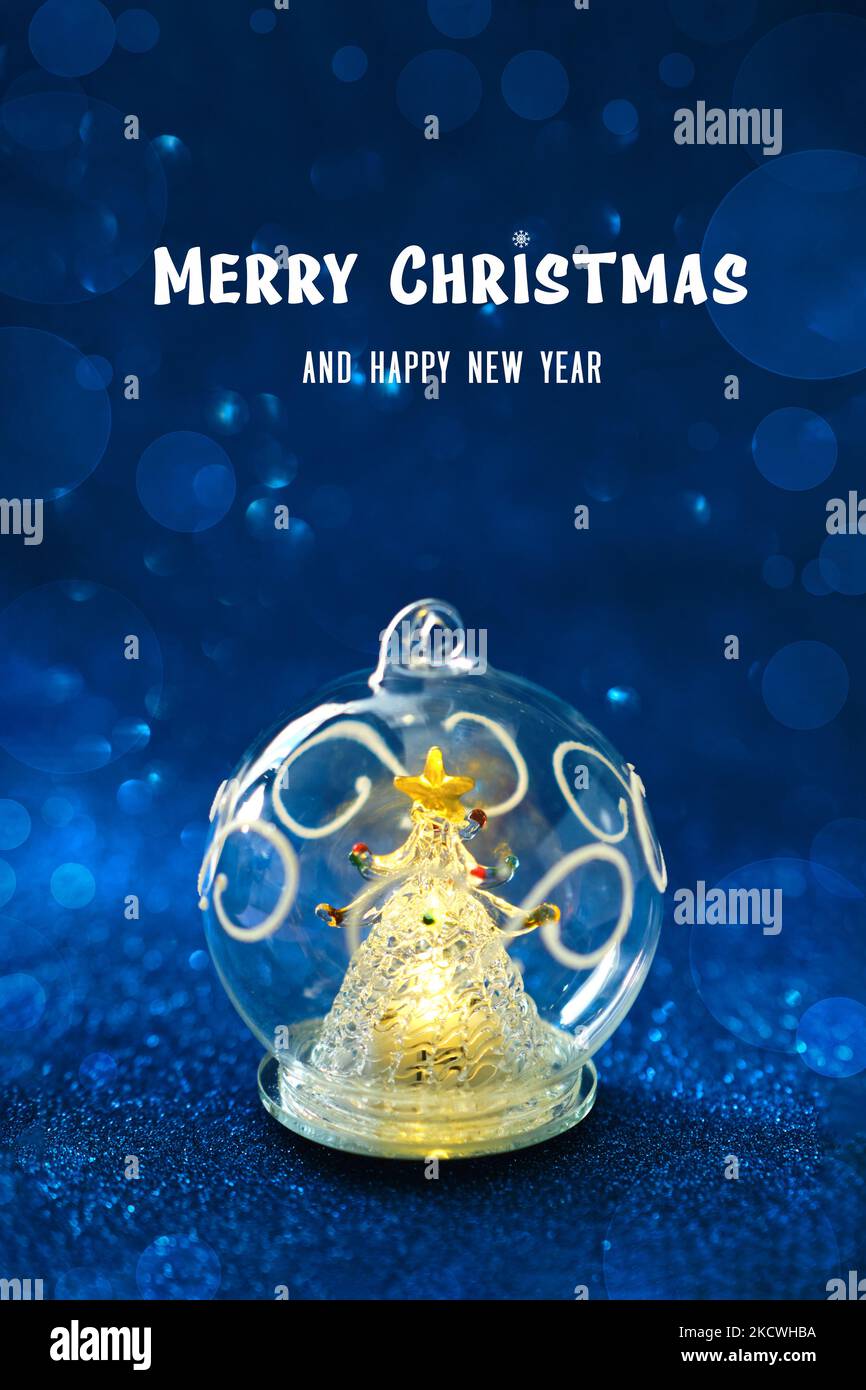 Palla di vetro con un albero di Natale incandescente all'interno Foto Stock