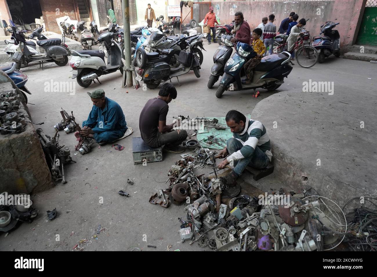 Lavoratori appiattire rottami di metallo da parti di automobile fuori di un workshop a Nuova Delhi, India il 24 novembre 2021. La Reserve Bank of India prevede una crescita del PIL del 9,5 per cento quest'anno fiscale, mentre la proiezione media varia tra il 8,5 per cento e il 10 per cento, rispetto alla precedente stima del 8 per cento per l'anno civile 2022. (Foto di Mayank Makhija/NurPhoto) Foto Stock