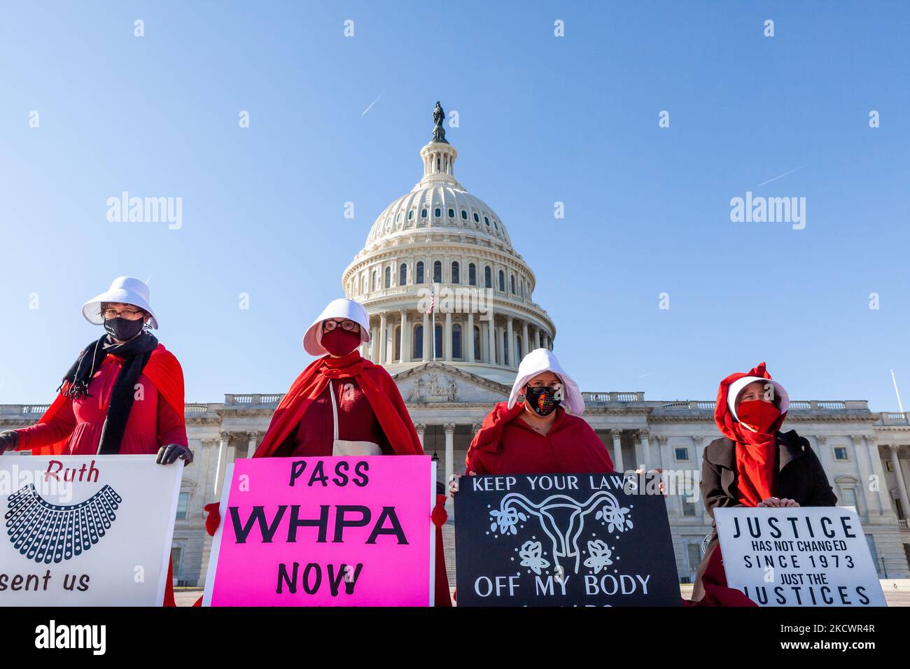 Dimostranti vestiti come corsine dalla protesta di racconto della serva per i diritti riproduttivi davanti al Campidoglio degli Stati Uniti, davanti alle argomentazioni di Dobbs contro Jackson Women's Health Organization davanti alla Corte Suprema il 1 dicembre. (Foto di Allison Bailey/NurPhoto) Foto Stock