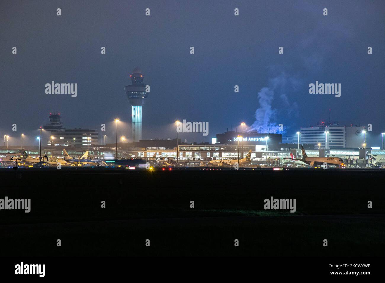 Vista notturna dell'aeroporto Schiphol di Amsterdam AMS con aereo alle porte. 14 casi della nuova variante COVID-19 Omicron sono stati confermati nei Paesi Bassi da passeggeri arrivati nella città olandese dal Sudafrica. Più di 600 passeggeri sono stati testati dai 2 voli con 61 confermati positivi per Covid-19. La polizia olandese ha arrestato in precedenza due passeggeri che si trovano in un hotel di quarantena mentre cercavano di fuggire. Molti paesi hanno sospeso i voli per il Sudafrica in un periodo già difficile con la pandemia di coronavirus che ha avuto un impatto negativo sul business dell'aviazione. Foto Stock