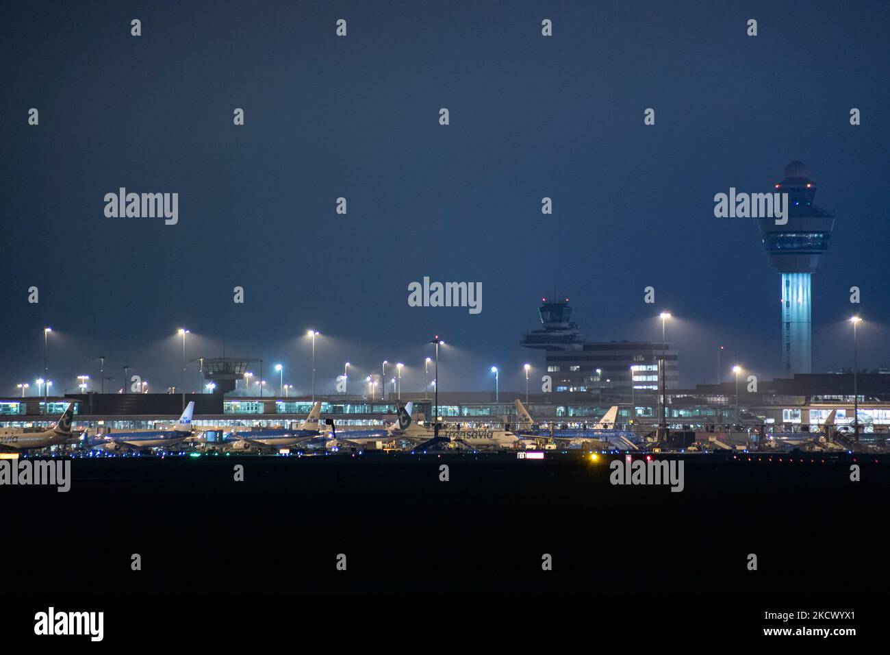 Vista notturna dell'aeroporto Schiphol di Amsterdam AMS con aereo alle porte. 14 casi della nuova variante COVID-19 Omicron sono stati confermati nei Paesi Bassi da passeggeri arrivati nella città olandese dal Sudafrica. Più di 600 passeggeri sono stati testati dai 2 voli con 61 confermati positivi per Covid-19. La polizia olandese ha arrestato in precedenza due passeggeri che si trovano in un hotel di quarantena mentre cercavano di fuggire. Molti paesi hanno sospeso i voli per il Sudafrica in un periodo già difficile con la pandemia di coronavirus che ha avuto un impatto negativo sul business dell'aviazione. Foto Stock