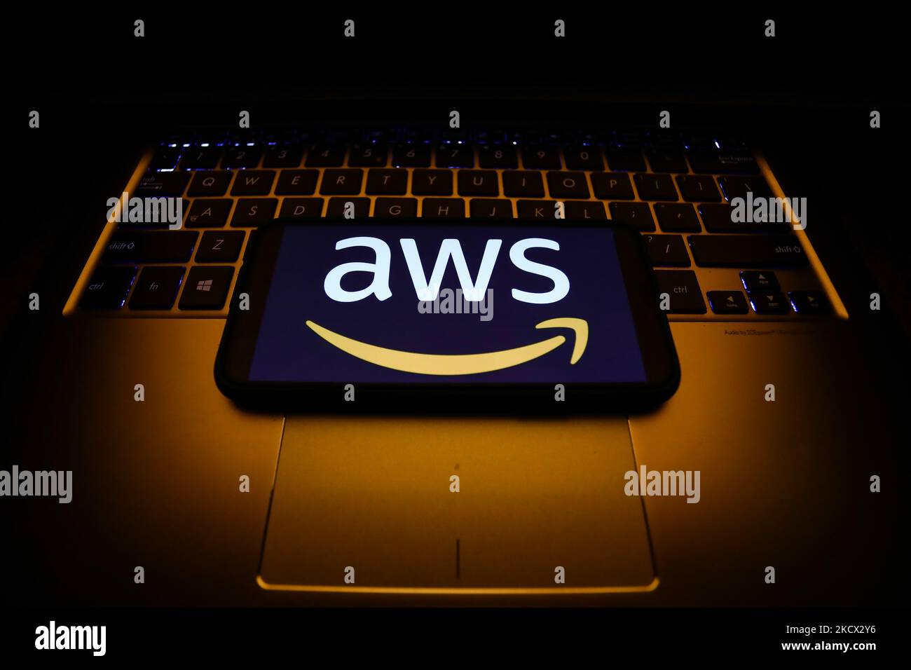 Il logo Amazon Web Services visualizzato sullo schermo di un telefono e la tastiera di un computer portatile sono visibili in questa immagine scattata a Cracovia il 1 dicembre 2021. (Foto di Jakub Porzycki/NurPhoto) Foto Stock