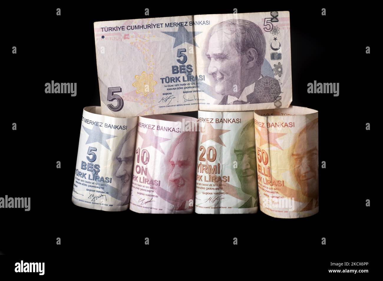 Foto Illustrazione delle banconote turche di Lira su sfondo nero e un nastro di misurazione come simbolo della contrazione economica e della moneta. La lira colpisce un nuovo record basso come la valuta ha esteso le perdite per il commercio oltre $13,73 per dollaro degli Stati Uniti e 15,51 euro. La lira turca scivola a livelli bassi dopo che il presidente Erdogan ha raddoppiato la politica sui tassi. Illustrazione delle banconote in lira turche, la valuta della Turchia, in turco chiamato Türk lire, con il segno: E codice TRY o TL. Il lato anteriore del becco ha ritratti di Mustafa Kemal Atatürk. Amsterdam, Paesi Bassi il 33 dicembre 2021. (Foto di Nicolò Foto Stock