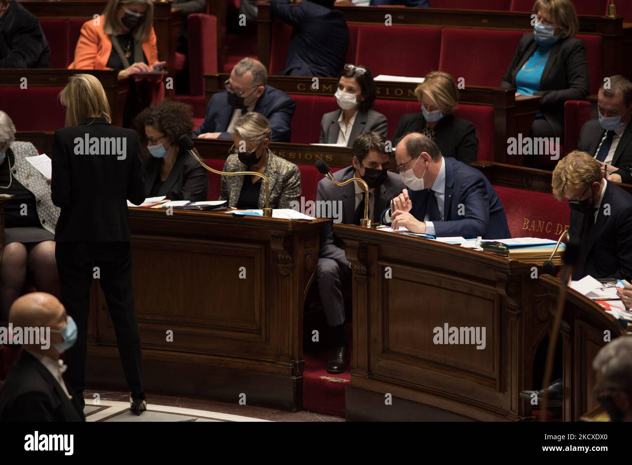 Il portavoce del governo Gabriel Attal discute con il primo ministro Jean Castex durante un discorso del vice ministro dell'Economia Agnes Pannier-Runacher (da dietro), durante la sessione delle interrogazioni al governo del Parlamento, a Parigi, 7 dicembre 2021. (Foto di Andrea Savorani Neri/NurPhoto) Foto Stock