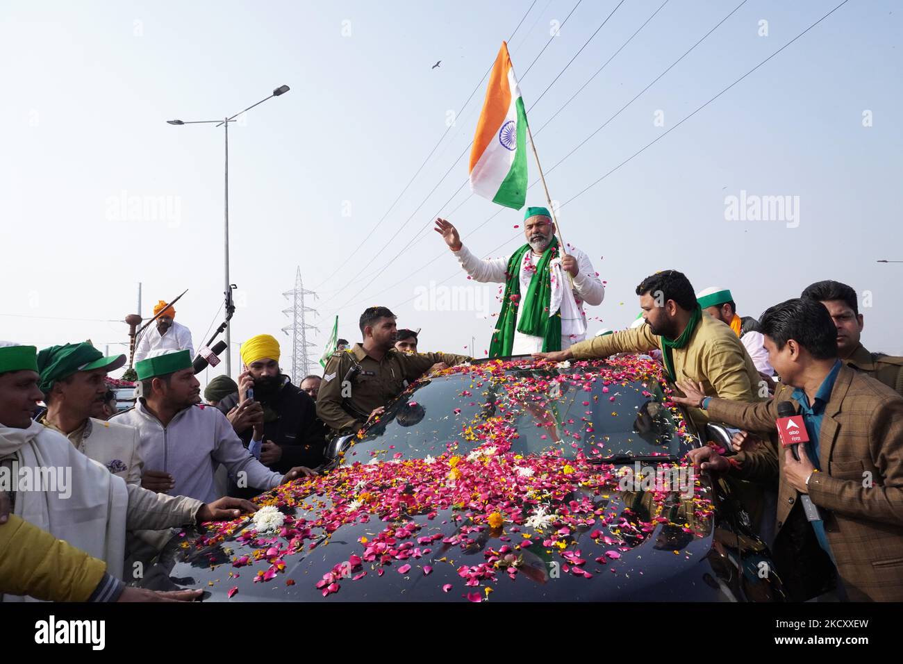 Rakesh Tikait, leader dell'Unione di Bharatiya Kisan (BKU), uno dei più grandi sindacati che rappresentano gli agricoltori, detiene la bandiera nazionale indiana in quanto gli agricoltori hanno lasciato un luogo di protesta, dopo che il governo ha accettato di accettare per quanto riguarda una serie di questioni, compresa la garanzia sul prezzo minimo di sostegno (MSP); Al confine di Ghazipur alla periferia di Nuova Delhi, India il 15 dicembre 2021. (Foto di Mayank Makhija/NurPhoto) Foto Stock