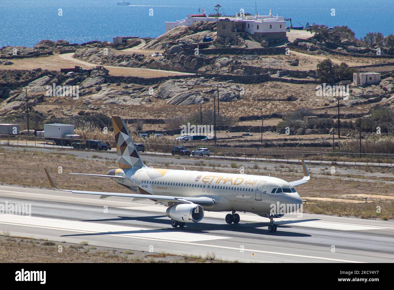 Etihad Airways Airbus A320 come visto taxiing, partenza e volo da Mykonos Aeroporto JMK. L'aereo con registrazione A6-EIU porta il passeggero dopo il decollo all'aeroporto di Abu Dhabi. Etihad è il secondo portatore di bandiera degli Emirati Arabi Uniti. L''isola greca di Myconos è una meta turistica mediterranea famosa per le vacanze nelle Cicladi, nel Mar Egeo con gli iconici edifici imbiancati, le spiagge sabbiose e le famose feste nei bar sulla spiaggia. L'aviazione, i viaggi, il tempo libero, l'industria del turismo e il traffico passeggeri stanno gradualmente afflicando un periodo difficile con il Co Foto Stock