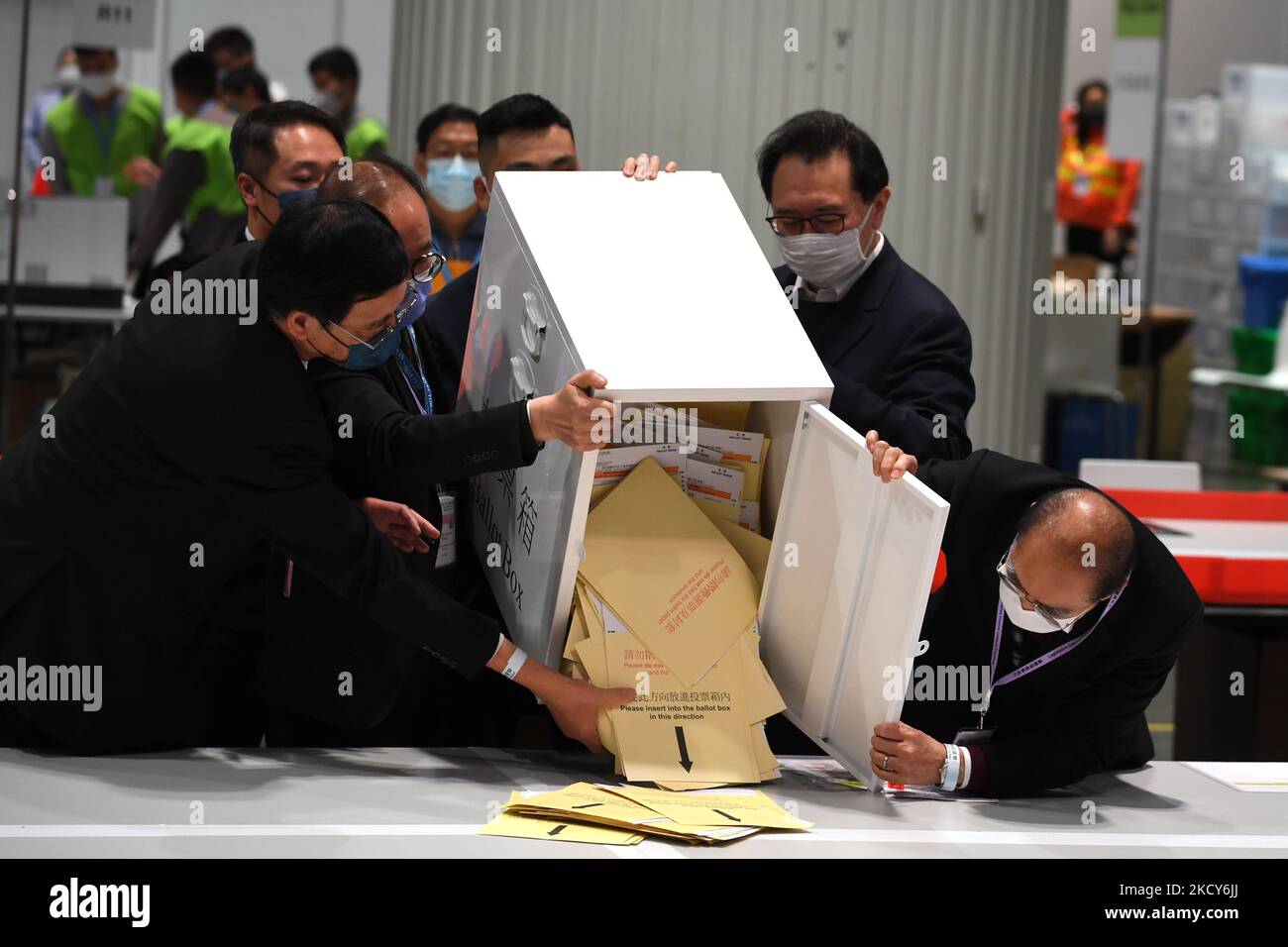 I funzionari si vedono riversare i voti da una scheda elettorale al tavolo di conteggio nella stazione centrale di conteggio a Hong Kong, 19 dicembre 2021. Hong Kong ha tenuto oggi le sue elezioni legislative del 2021. (Foto di Vernon Yuen/NurPhoto) Foto Stock