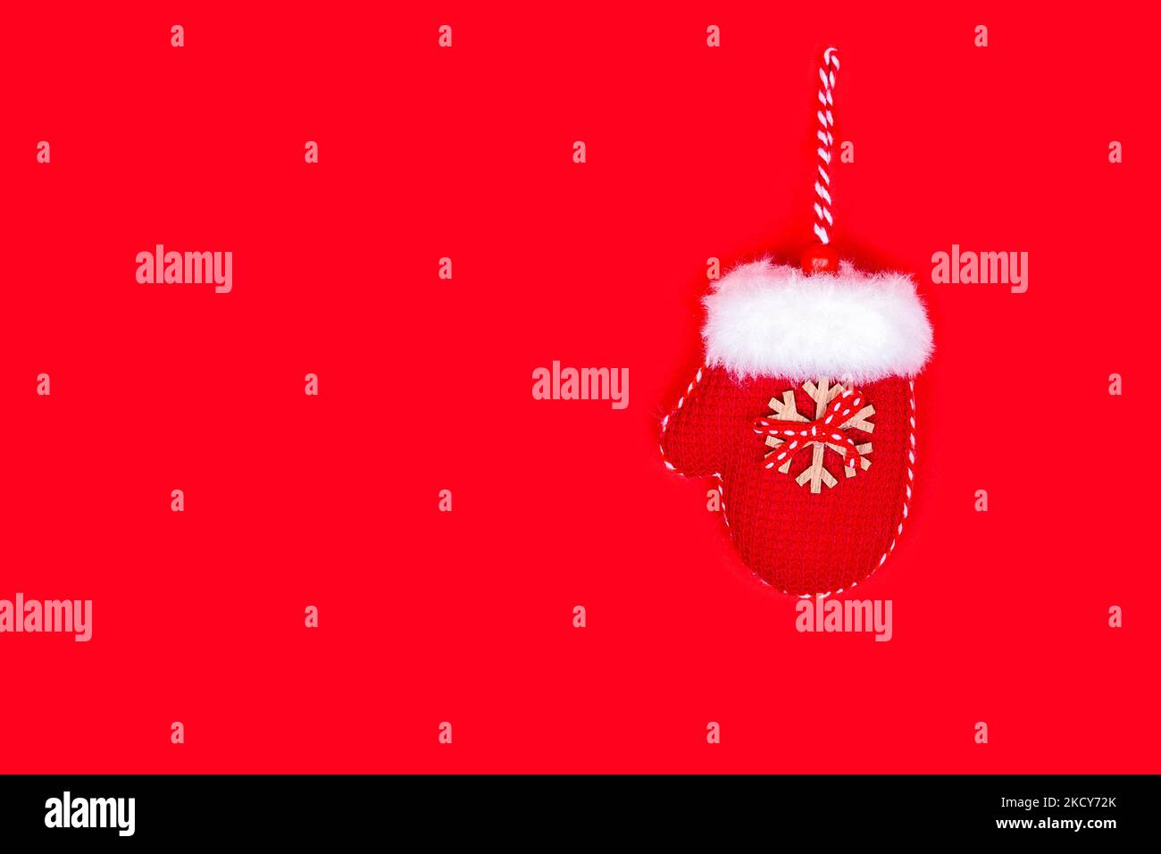 Natale Mitten con corde su uno sfondo rosso. Banner creativo di Capodanno, cartolina con spazio per il testo Foto Stock