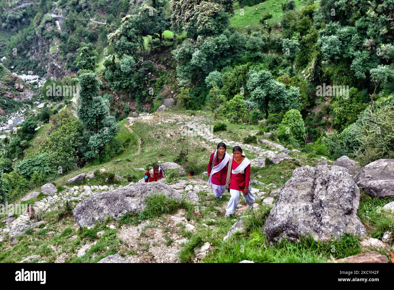 Le ragazze della scuola in uniforme camminano lungo un sentiero di pietra  insidioso che taglia attraverso la giungla e conduce in alto nelle montagne  mentre viaggiano 3-4 ore (due volte al giorno)