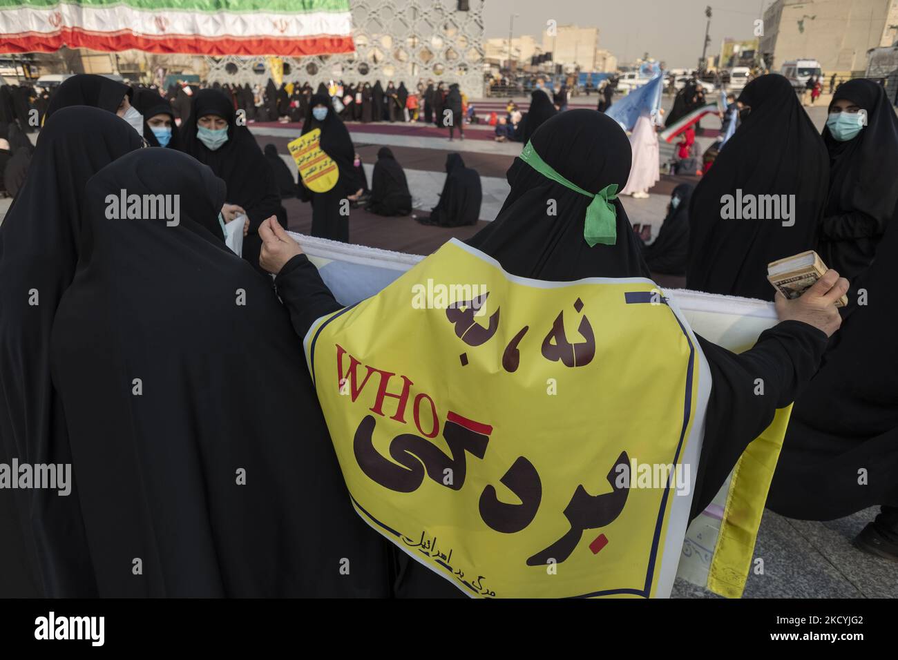 Una donna iraniana che indossa un banner anti-Organizzazione Mondiale della Sanità (OMS) con un copione persiano che legge, No alla schiavitù, mentre frequenta un raduno nella piazza Imam Hussein nel sud-est di Teheran il 30 dicembre 2021. I sostenitori del leader supremo iraniano Ayatollah Ali Khamenei partecipano a un raduno per celebrare l’anniversario delle manifestazioni anti-opposizione del 2009 dicembre a Teheran. (Foto di Morteza Nikoubazl/NurPhoto) Foto Stock