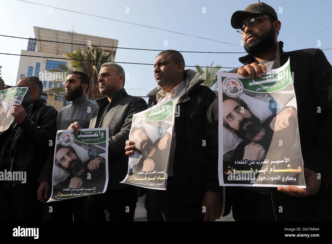 I manifestanti palestinesi tengono foto di Hisham Abu Hawash, 40, Che è stato in sciopero della fame per più di 139 giorni dopo che è stato arrestato e messo in detenzione amministrativa da Israele , davanti all'Ufficio dell'Alto Commissario delle Nazioni Unite per i diritti umani a Gaza City, domenica 2 gennaio 2022. I parenti di Abu Hawash hanno detto che era in condizioni critiche in un ospedale israeliano. (Foto di Majdi Fathi/NurPhoto) Foto Stock