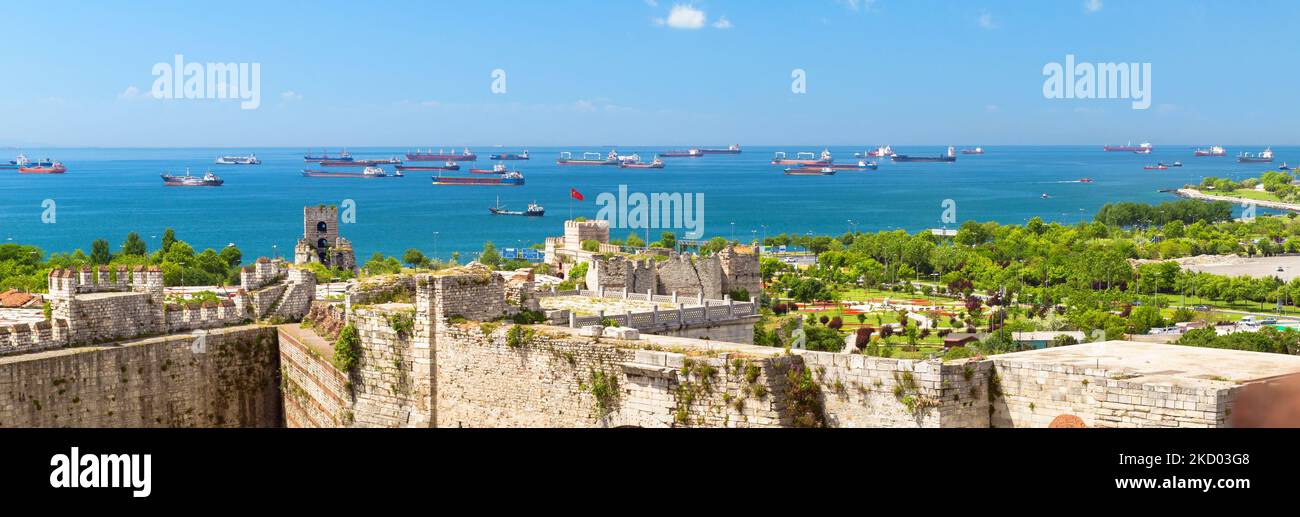 Yedikule Fortezza che domina il mare con navi, Istanbul, Turchia. Panorama del vecchio castello, delle mura di Costantinopoli e delle navi da carico. Tema di expor di grano Foto Stock