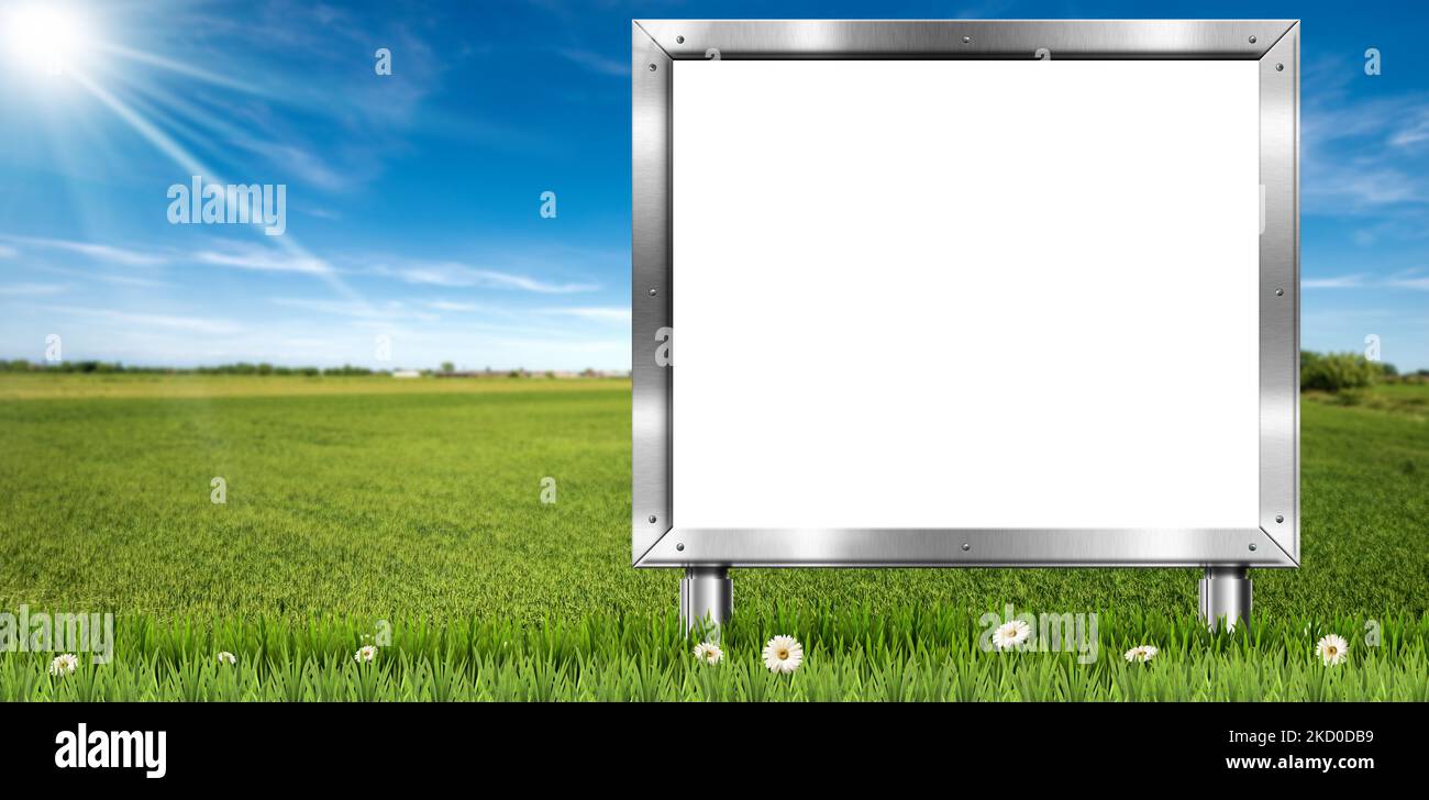Cartellone in metallo bianco con spazio copia su un paesaggio di campagna, erba verde, fiori margherite, cielo blu con nuvole e raggi solari. Foto Stock