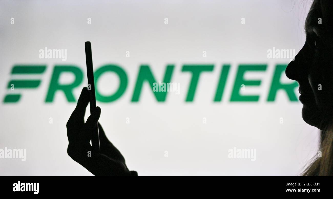 Immagine di una donna che tiene un telefono cellulare davanti al logo Frontier Airlines visualizzato sullo schermo di un computer. Martedì 12 gennaio 2021, a Edmonton, Alberta, Canada. (Foto di Artur Widak/NurPhoto) Foto Stock