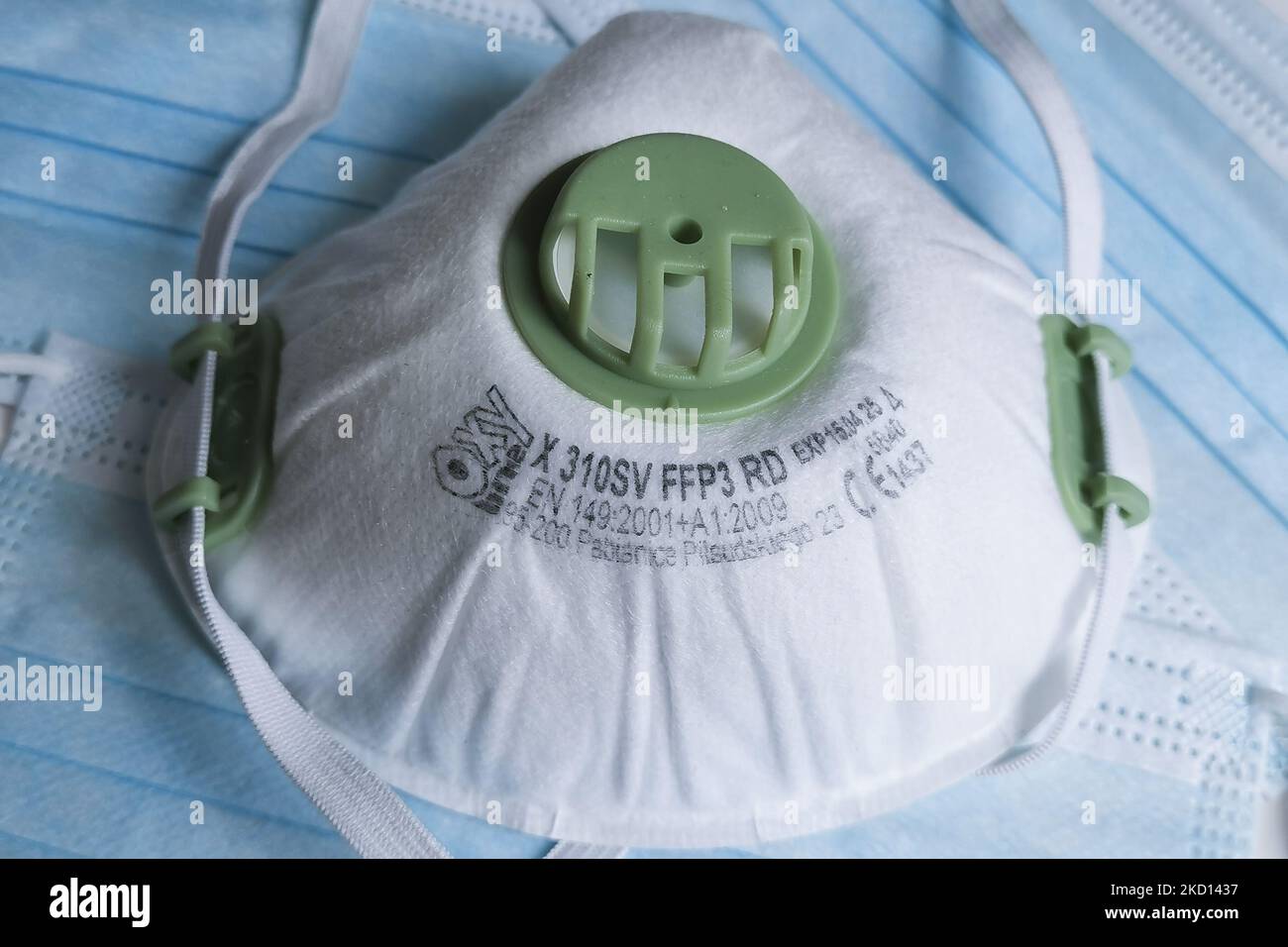 Una maschera facciale FFP3 viene fotografata sullo sfondo delle maschere chirurgiche per foto illustrativa durante la diffusione della quinta onda della pandemia di coronavirus. Gliwice, Polonia il 23 gennaio 2022. (Foto di Beata Zawrzel/NurPhoto) Foto Stock