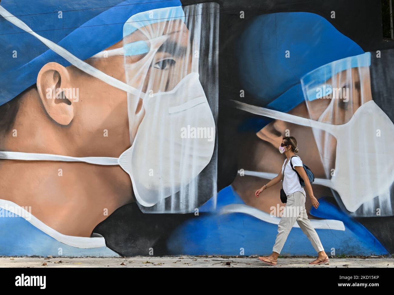 Una donna passa davanti a un murale di medici che indossano maschere dipinte nel centro di Merida dagli artisti messicani Mare - Noookye. Domenica 23 gennaio 2022, a Merida, Yucatan, Messico. (Foto di Artur Widak/NurPhoto) Foto Stock