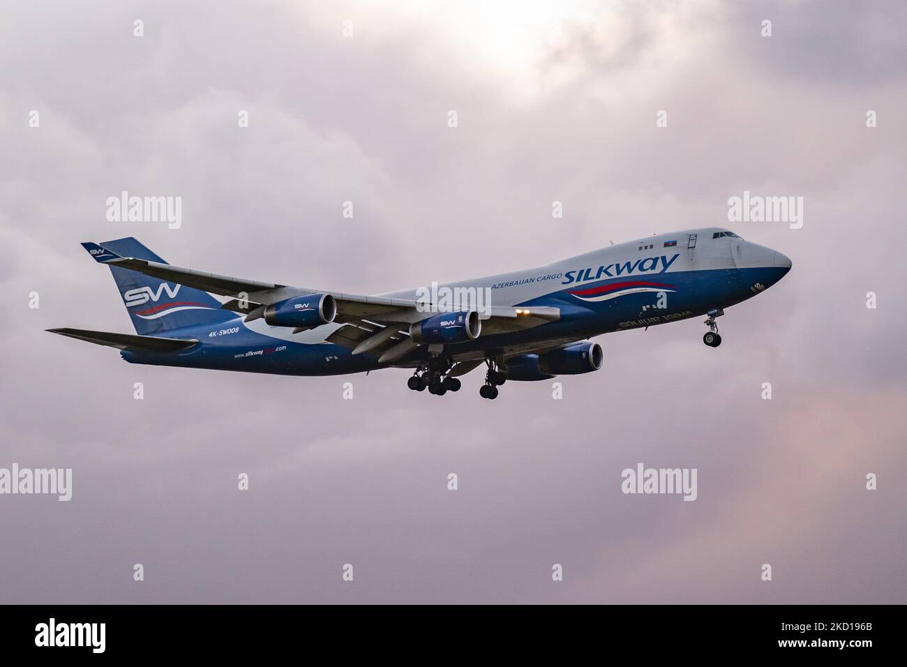 Silk Way West Airlines Jumbo Jet Boeing 747-400F cargo Edition visto volare e atterrare all'aeroporto Schiphol di Amsterdam AMS EHAM durante una serata nuvolosa e buia. L'aereo Boeing 747 ha la registrazione 4K-SW008. Silk Way West Airlines è una compagnia aerea azerbaigiana cargo con la sua sede centrale e principale base operativa presso l'aeroporto internazionale Heydar Aliyev di Baku, Azerbaigian. I voli cargo hanno aumentato la domanda e volano di più mentre il traffico dell'industria dell'aviazione dei passeggeri sta gradualmente considerando un periodo difficile con la pandemia di coronavirus di Covid-19 che ha un impatto negativo sul business dei viaggi Foto Stock