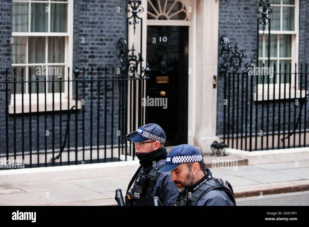Gli ufficiali di polizia passano davanti alla porta di 10 Downing Street poco prima che il primo ministro britannico Boris Johnson lasci per la sua apparizione settimanale del primo ministro (PMQ) nella Camera dei Comuni a Londra, in Inghilterra, il 26 gennaio 2022. (Foto di David Cliff/NurPhoto) Foto Stock