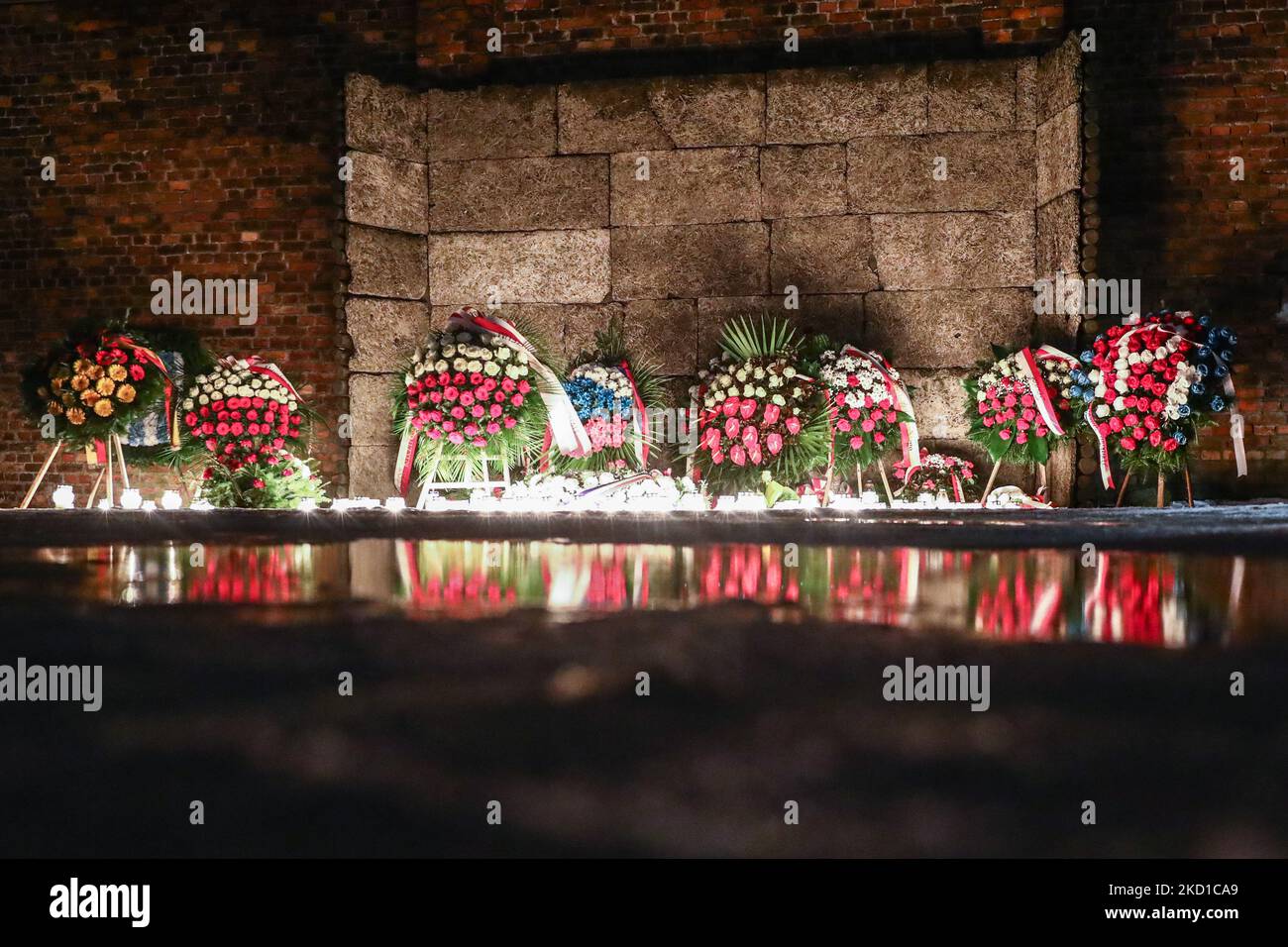 Candele e fiori davanti al Muro della morte al Memoriale di Auschwitz-Birkenau, durante il 77th° anniversario di Auschwitz - Liberazione di Birkenau, a Oswiecim, Polonia, il 27 gennaio 2022. (Foto di Beata Zawrzel/NurPhoto) Foto Stock