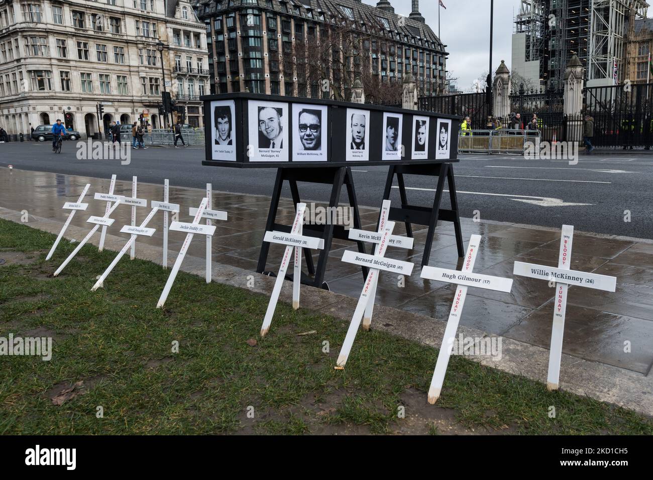 LONDRA, REGNO UNITO - 27 GENNAIO 2022: Croci simboliche e una bara con i nomi e le immagini delle vittime della domenica di sangue si trovano fuori dalle Camere del Parlamento durante una veglia commemorativa del 50th° anniversario della domenica di sangue e una protesta contro le proposte del governo britannico di amnistia per le forze statali coinvolte il 27 gennaio; 2022 a Londra, Inghilterra. Domenica 30 gennaio 1972, i soldati britannici hanno aperto il fuoco su civili disarmati partecipando a una marcia per i diritti civili a Derry, uccidendo tredici e ferendo quindici persone, con il giorno che diventa noto come Bloody Sunday. (Foto di W Foto Stock