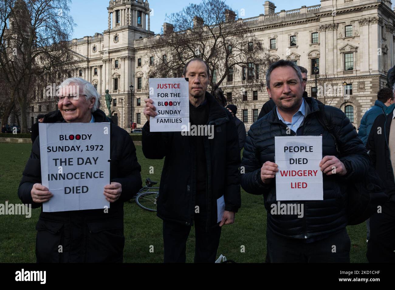 LONDRA, REGNO UNITO - 27 GENNAIO 2022: Gli uomini sono in possesso di cartelli che richiamano l'indagine iniziale sulla Bloody Sunday condotta da Lord Widgery e chiedono giustizia alle famiglie delle vittime durante una veglia al di fuori del Parlamento per commemorare il 50th° anniversario della Bloody Sunday e protestare contro le proposte del governo britannico di amnistia per le forze statali Coinvolto il 27 gennaio 2022 a Londra, Inghilterra. Domenica 30 gennaio 1972, i soldati britannici hanno aperto il fuoco su civili disarmati partecipando a una marcia per i diritti civili a Derry uccidendo tredici e ferendo quindici persone, con il giorno in cui ci si trova Foto Stock