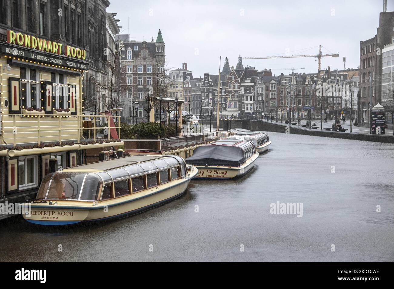 Le barche che solitamente fanno il giro turistico per i turisti sono viste ormeggiate nei canali di Amsterdam. Vita quotidiana durante il blocco alla quarta ondata della pandemia. Locali e alcuni turisti nelle tranquille strade di Amsterdam durante il blocco nella capitale olandese con negozi e negozi che appaiono con chiuso con la tapparella metallica giù, caffè, bar e ristoranti anche chiusi con tavoli e sedie delle terrazze chiuse. I Paesi Bassi sono stati la prima nazione europea a dichiarare il blocco completo per combattere la nuova variante di Omicron che si surge. Dopo un improvviso ordine governativo prima di Natale, il Foto Stock