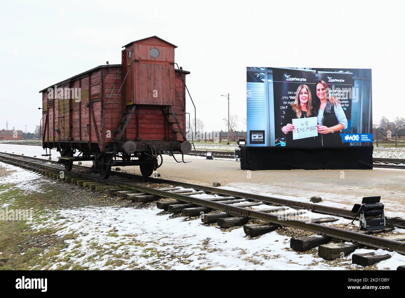 Una carrozza ferroviaria originale usata per le deportazioni e uno schermo che mostra i video 'We Remember' del Congresso Mondiale Ebraico per il 77th° anniversario di Auschwitz - Birkenau Liberation sono visti nel campo di concentramento e sterminio nazista di Auschwitz II-Birkenau a Brzezinka vicino Oswiecim, Polonia il 27 gennaio 2022. (Foto di Beata Zawrzel/NurPhoto) Foto Stock