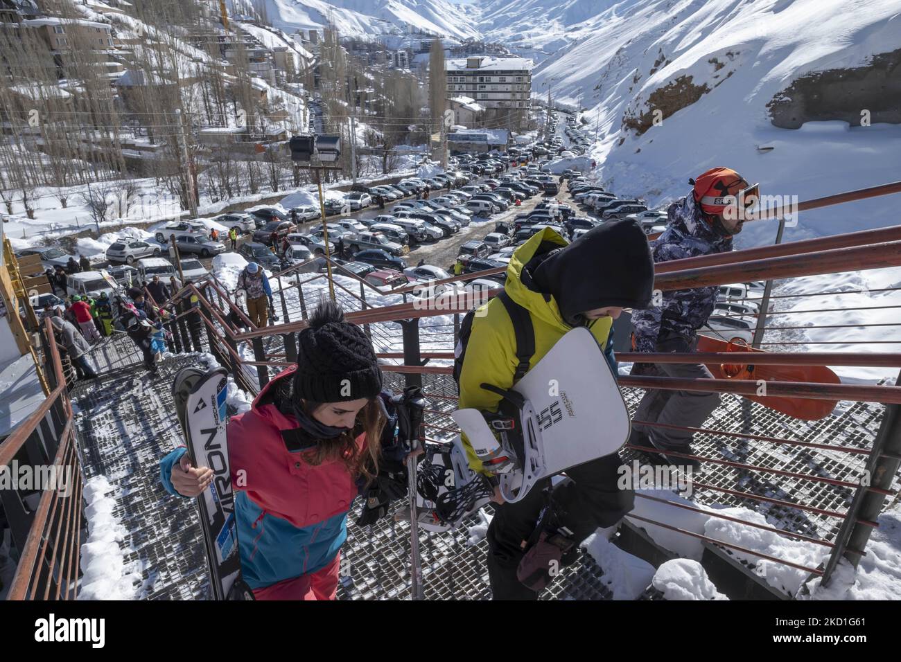 I giovani iraniani che trasportano le loro attrezzature da sci e snowboard mentre salgono le scale prima della stazione sciistica di Darbandsar passando il cancello 67 km (42 miglia) a nord-est di Teheran il 28 gennaio 2022. Nonostante la prevalenza della variante Omicron della nuova malattia di coronavirus (COVID-19) in Iran, La città di Teheran non è ancora in una situazione rossa (ad alto rischio) e la gente può ancora divertirsi e sciare sulle piste da sci. Ma secondo l'ultimo rapporto dell'Agenzia di informazione metropolitana dell'Iran (IMNA), nella nuova situazione della prevalenza della variazione di Omicron di Covid-19 in Iran, Provincia di Qom che è il neighbo Foto Stock