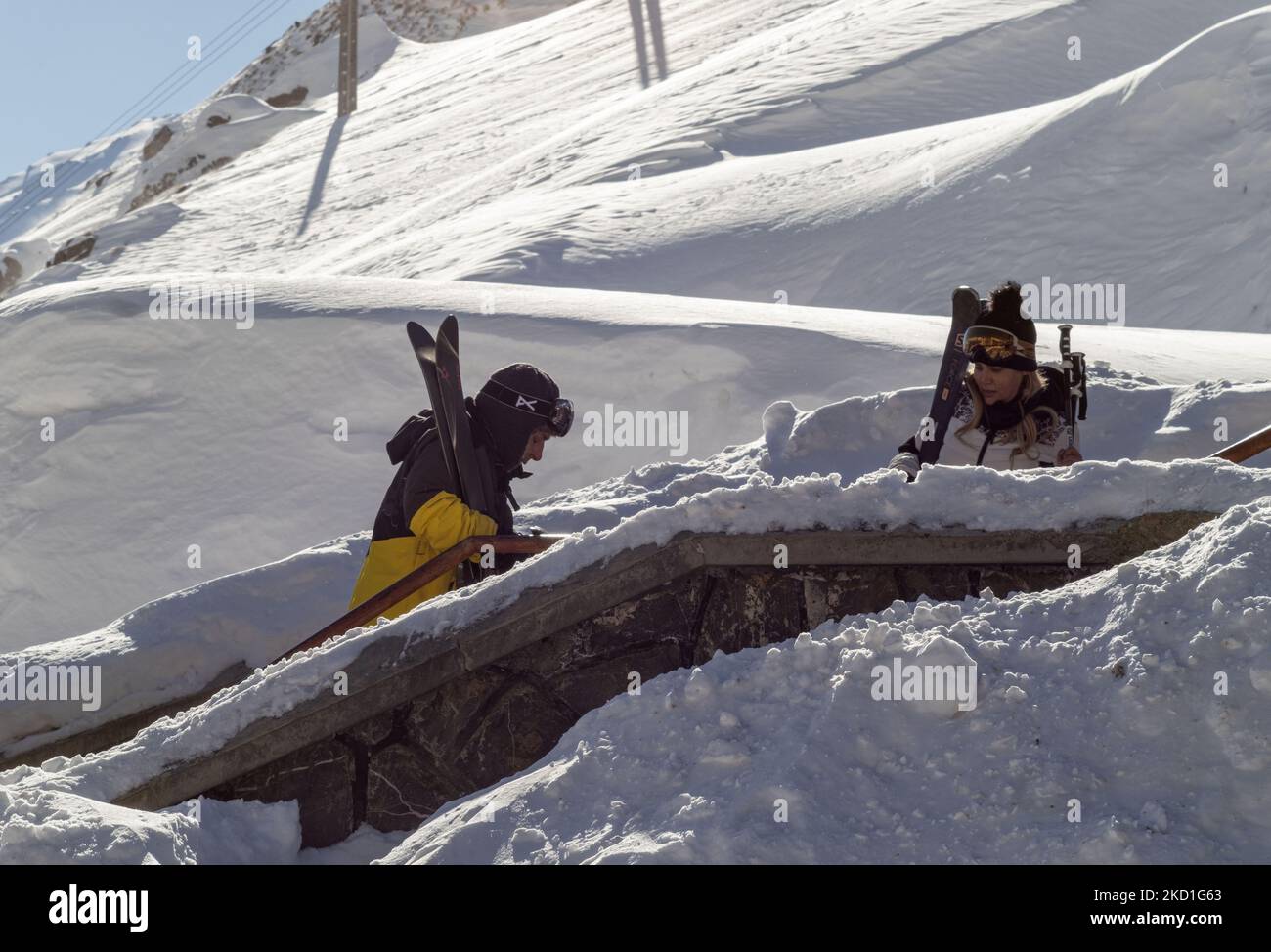 Una coppia iraniana che trasporta le proprie attrezzature da sci mentre sale le scale prima della stazione sciistica di Darbandsar passando il cancello 67 km (42 miglia) a nord-est di Teheran il 28 gennaio 2022. Nonostante la prevalenza della variante Omicron della nuova malattia di coronavirus (COVID-19) in Iran, La città di Teheran non è ancora in una situazione rossa (ad alto rischio) e la gente può ancora divertirsi e sciare sulle piste da sci. Ma secondo l'ultimo rapporto dell'Agenzia di informazione metropolitana dell'Iran (IMNA), nella nuova situazione della prevalenza della variazione di Omicron di Covid-19 in Iran, Provincia di Qom, che è il vicino di Teheran, io Foto Stock