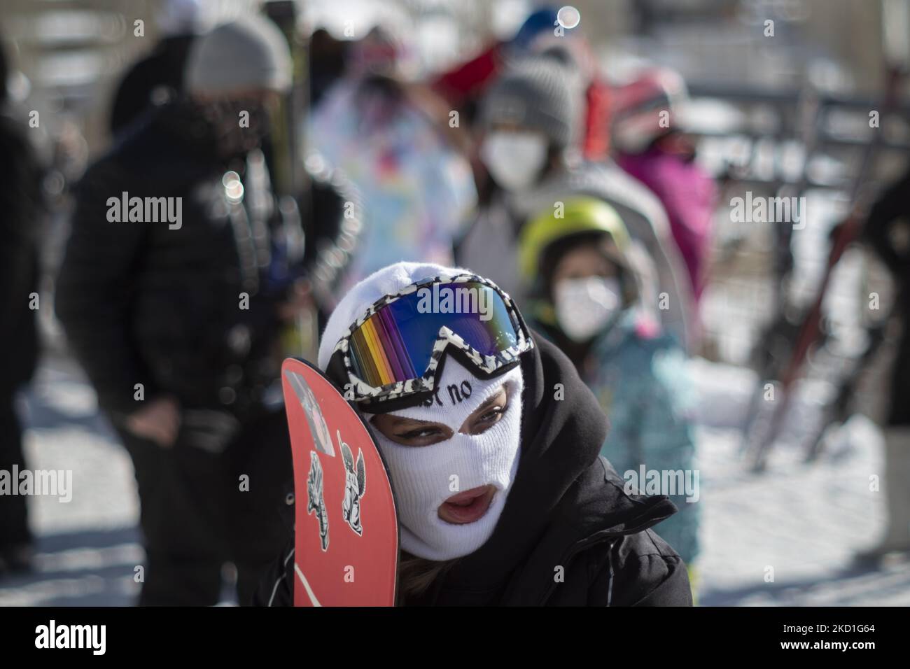 Una sciatrice iraniana ha la sua attrezzatura da snowboard mentre si trova davanti alla stazione sciistica di Darbandsar, passando il cancello di 67 km (42 miglia) a nord-est di Teheran il 28 gennaio 2022. Nonostante la prevalenza della variante Omicron della nuova malattia di coronavirus (COVID-19) in Iran, La città di Teheran non è ancora in una situazione rossa (ad alto rischio) e la gente può ancora divertirsi e sciare sulle piste da sci. Ma secondo l'ultimo rapporto dell'Agenzia di informazione metropolitana dell'Iran (IMNA), nella nuova situazione della prevalenza della variazione di Omicron di Covid-19 in Iran, Provincia di Qom, che è il vicino di Teheran, io Foto Stock