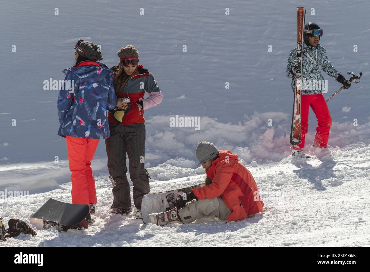 Donne iraniane snowboarder parlare tra loro come uno sciatore a piedi accanto a loro in cima a una pista nella stazione sciistica di Darbandsar 67Km (42 miglia) nord-est di Teheran il 28 gennaio 2022. Nonostante la prevalenza della variante Omicron della nuova malattia di coronavirus (COVID-19) in Iran, La città di Teheran non è ancora in una situazione rossa (ad alto rischio) e la gente può ancora divertirsi e sciare sulle piste da sci. Ma secondo l'ultimo rapporto dell'Agenzia di informazione metropolitana dell'Iran (IMNA), nella nuova situazione della prevalenza della variazione di Omicron di Covid-19 in Iran, Provincia di Qom, che è il vicino di Teheran, io Foto Stock