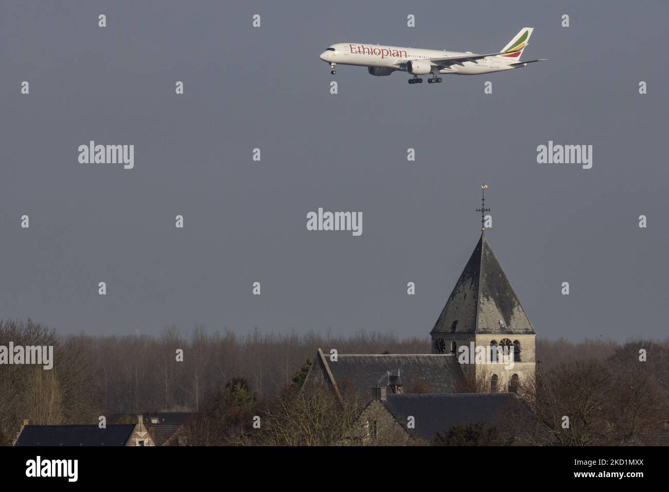 Etiopian Airlines Airbus A350 velivolo a fusoliera larga visto che sorvola una chiesa in arrivo per atterrare all'aeroporto Zaventem BRU di Bruxelles. L'aereo commerciale in arrivo trasporta passeggeri e merci dalla capitale dell'Etiopia Adis Abeba. L'aereo ha la registrazione ET-AVB e il nome Gelada Baboon. Etiope è il vettore di bandiera dell'Etiopia, ha una flotta di 127 passeggeri e 58 aerei da carico, di proprietà del governo e membro del gruppo aereo Star Alliance. Il settore dell'aviazione e il traffico di passeggeri stanno gradualmente affondando un periodo difficile con la panda del coronavirus Covid-19 Foto Stock