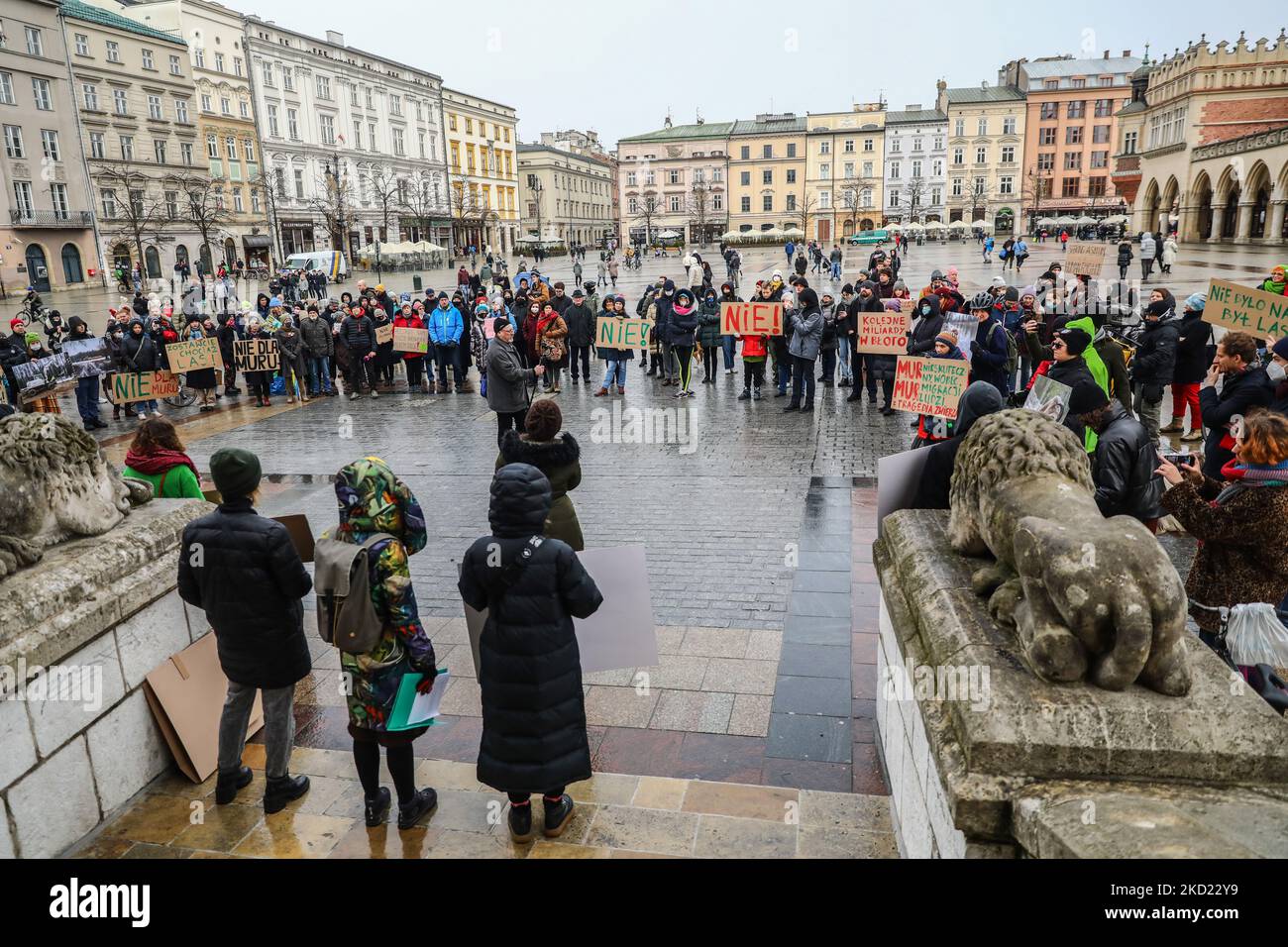 La gente si mostra nella piazza principale durante una protesta contro la costruzione di un muro al confine tra Polonia e Bielorussia. Cracovia, Polonia il 6 gennaio 2022. Il muro, che dovrebbe impedire ai migranti del Medio Oriente di attraversare passaggi illegali dalla Bielorussia, sarà alto fino a 18 piedi (5,5 metri) e si estenderà per 116 miglia (186 chilometri) lungo il confine orientale della Polonia, attraversando la foresta di Bialowieza, patrimonio mondiale dell'UNESCO. Gli scienziati e gli attivisti dell'ambiente sono preoccupati per i possibili effetti negativi della recinzione su specie preziose e sull'ecosistema forestale meglio conservato Foto Stock