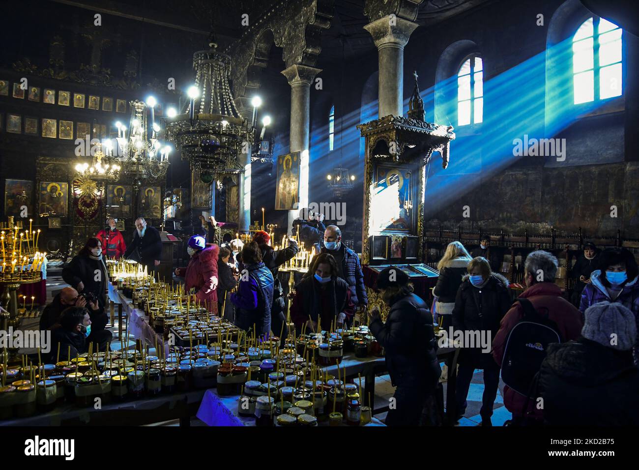 I fedeli illuminano le candele su vasi con miele durante un rituale religioso che segna il giorno di San Haralampi - il santo protettore ortodosso degli apicoltori - nella chiesa della Presentazione della Beata Vergine, a Blagoevgrad, Bulgaria occidentale, il 10 febbraio 2022. (Foto di Georgi Paleykov/NurPhoto) Foto Stock