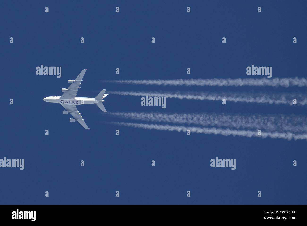 Qatar Airways Airbus A380 aereo a due piani sorvola a 40,000 metri nel cielo blu durante una giornata di sole sull'Europa, effettuando un collegamento aereo dalla capitale del Qatar aeroporto di Doha a Londra Heathrow LHR nel Regno Unito. A388 aereo jet a corpo largo sorvolante ha la stampa del logo QATAR sul fondo della fusoliera e sta lasciando dietro contraglie o tracce di condensazione, una linea di vapore bianca. Il modello A380 è un grande aereo di linea a carrozzeria larga, il più grande aereo passeggeri del mondo. Lo specifico quadjet double-deck ha la registrazione A7-APH ed è alimentato dal motore a reazione 4x EA Engine Alliance GP7200 Foto Stock