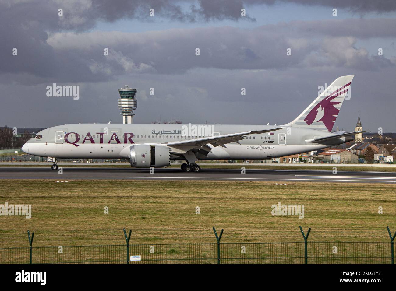 Qatar Airways Boeing 787-8 Dreamliner velivolo visto all'arrivo finale che vola, atterra e tassa nella capitale belga, l'aeroporto Zaventem BRU di Bruxelles di fronte alla torre di controllo e al terminal. Il Boeing B787 è un velivolo passeggeri moderno e avanzato, con carrozzeria larga e basso consumo di carburante, dotato di registrazione A7-BCP ed è alimentato da motori a getto 2x GE. L'aereo arriva alla città europea da Doha. Il QR è un vettore del golfo che effettua voli commerciali per passeggeri e merci, il vettore di bandiera statale del Qatar, membro del gruppo di alleanza delle compagnie aeree oneworld. L'industria aeronautica e passe Foto Stock