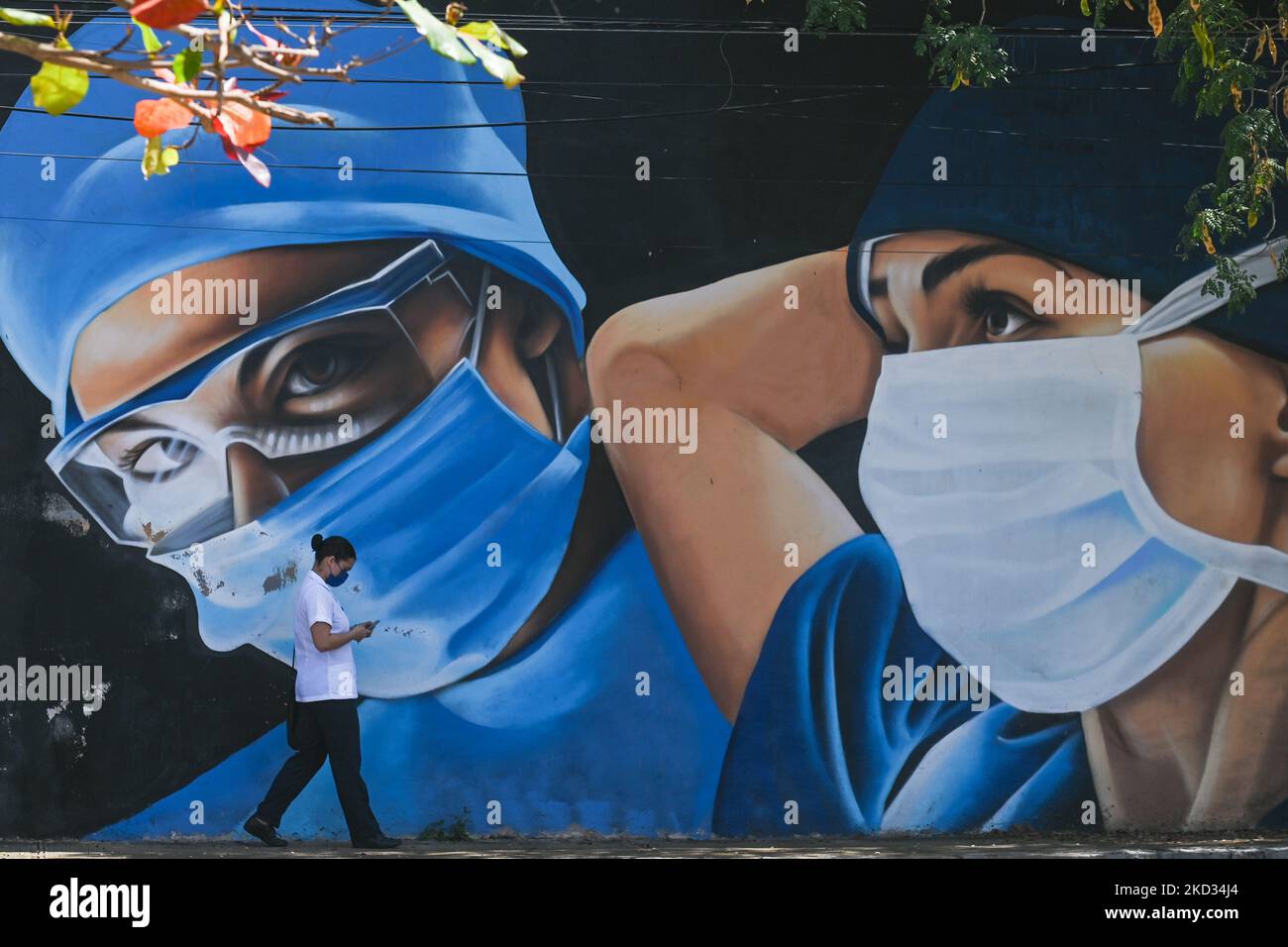 Una donna che indossa una maschera facciale passa davanti a un murale di medici dipinti nel centro di Merida da artisti messicani Mare - Noookye. Sabato 19 febbraio 2022 a Merida, Yucatan, Messico. (Foto di Artur Widak/NurPhoto) Foto Stock