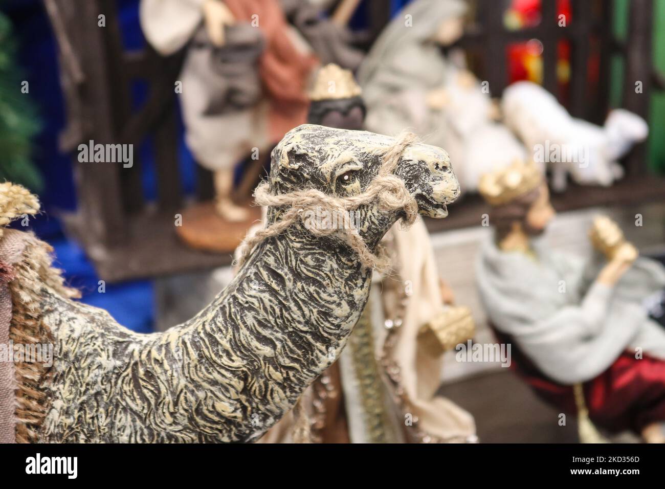 Primo piano della statuina del cammello della testa con figure sfocate della scena natività sullo sfondo Foto Stock