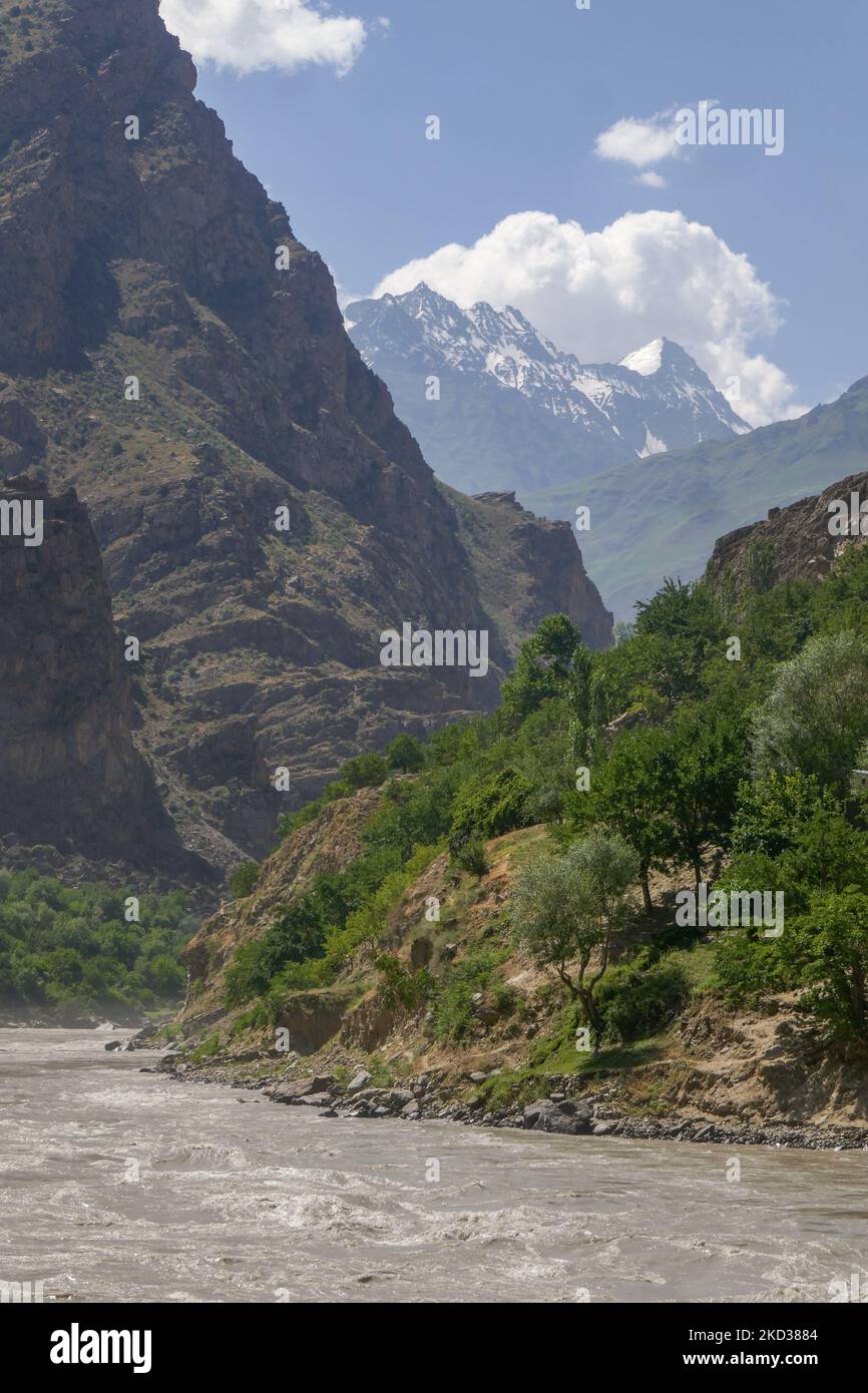 Vista panoramica sul lato afghano della valle del fiume Panj con montagne innevate sullo sfondo, Darvaz, Gorno-Badakshan, Tagikistan Pamir Foto Stock