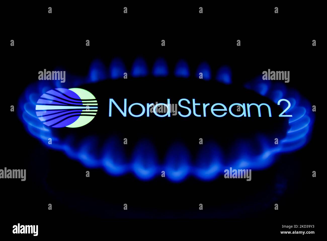 Le fiamme di un bruciatore a gas e il logo Nord Stream 2 visualizzato sullo schermo del telefono sono visibili in questa foto di illustrazione a esposizione multipla scattata a Cracovia il 22 febbraio 2022. (Foto di Jakub Porzycki/NurPhoto) Foto Stock
