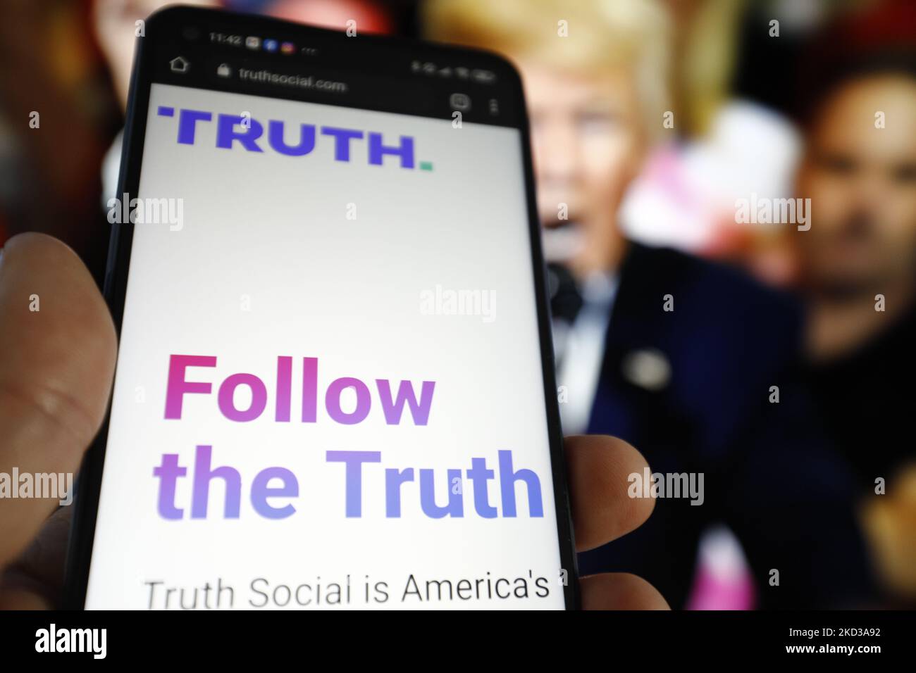 Il SITO WEB DELLA VERITÀ sociale è visto su un dispositivo mobile con un'immagine dell'ex presidente degli Stati Uniti Donald Trump sullo sfondo in questa foto illustrazione a Varsavia, Polonia, il 23 febbraio 2022. TRUTH Social è una piattaforma di social media recentemente sviluppata dal Trump Media and Technology Group (TMTG), il modello di Twitter. L’iniziativa è stata presa dopo che Trump stesso era stato bandito da Facebook e Twitter nel 2021. (Foto di Str/NurPhoto) Foto Stock