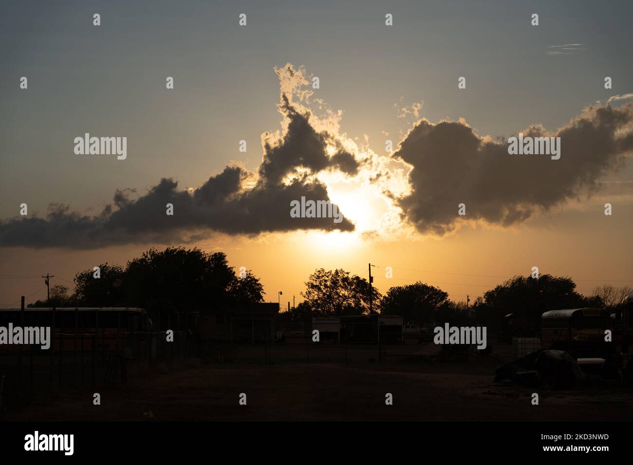 Un tramonto ardente sul villaggio con autobus e strutture tumbled-down Foto Stock
