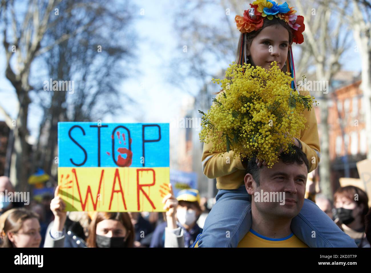 Una giovane ragazza dentro sulle grida di suo padre durante la protesta. Migliaia di persone hanno marciato a Tolosa contro la guerra condotta dal presidente russo Vladimir Putin contro l'Ucraina a meno di una settimana dall'inizio dell'offensiva. Gli ucraini erano numerosi perché Tolosa ha un'importante comunità di ucraini. Tolosa è gemellare con Kiev. La Francia ha chiuso il proprio spazio aereo agli aeromobili russi e la Russia sta gradualmente interrando il sistema bancario SWIFT. Putin ha affermato di aver messo le sue forze di difesa nucleari in alto allarme. Tolosa. Francia. Febbraio 27th 2021. (Foto di Alain Pitton/NurPhoto) Foto Stock