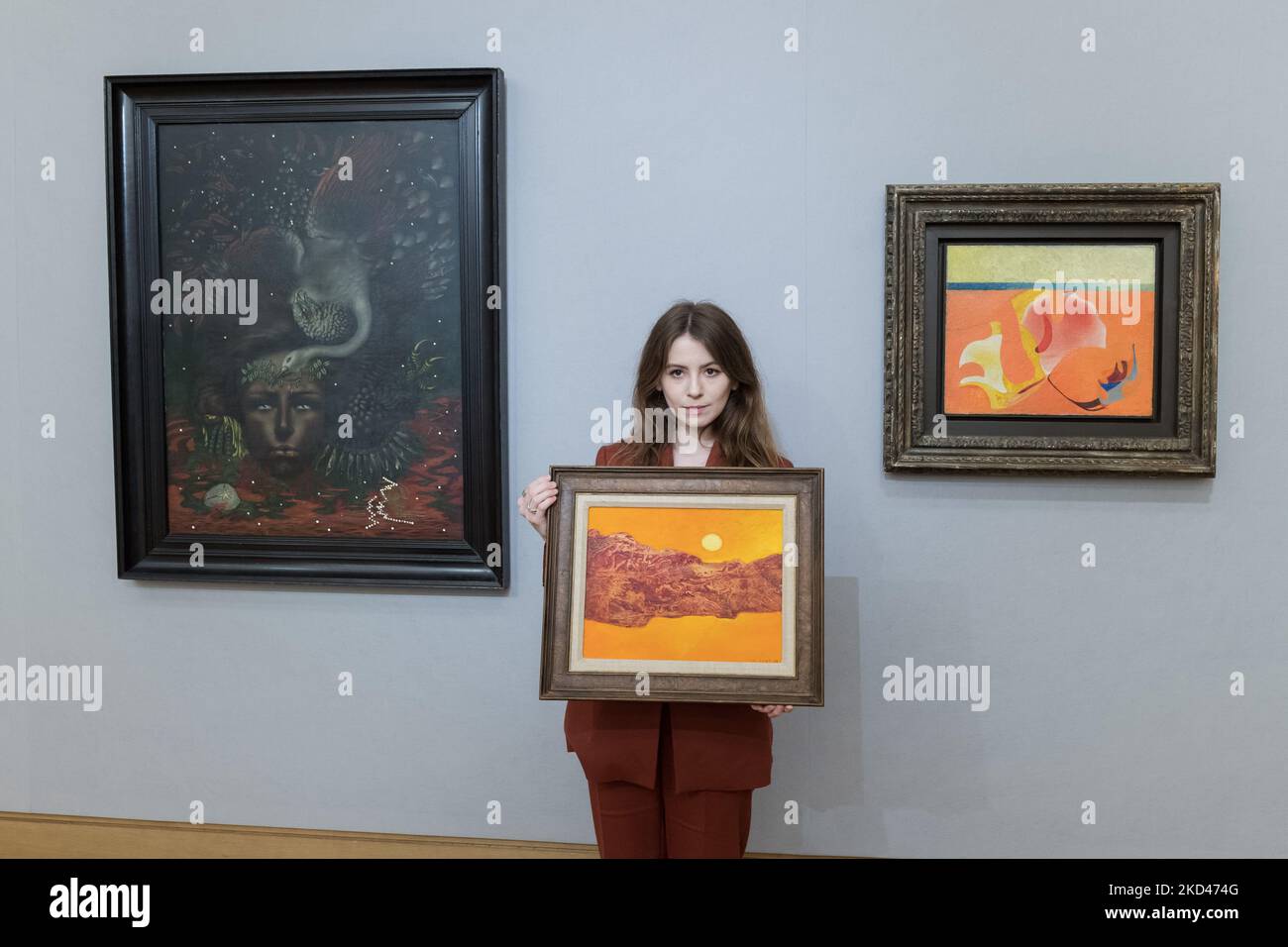 LONDRA, REGNO UNITO - 04 MARZO 2022: Un membro dello staff posa con 'But in Color' (dipinto nel 1962) di Max Ernst (1891-1976), stima: £180.000-250.000 (centro), 'Portrait d'Arthur Rimbaud' (dipinto nel 1933) di Valentine Hugo (1887-1968), stima: £400.000 - 600.000 (a sinistra) e 'Méduse circonflexe' (dipinta nel 1933) di Max Ernst (1891-1976), stima: £250.000 - 350.000 (a destra) durante una telefonata per The Mind’s Eye: Vendita surrealista alla casa d'aste Bonhams il 04 marzo 2022 a Londra, Inghilterra. (Foto di Wiktor Szymanowicz/NurPhoto) Foto Stock
